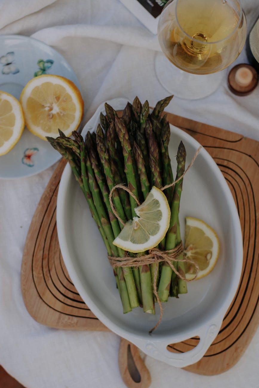 asparagus with lemon on plate on table
