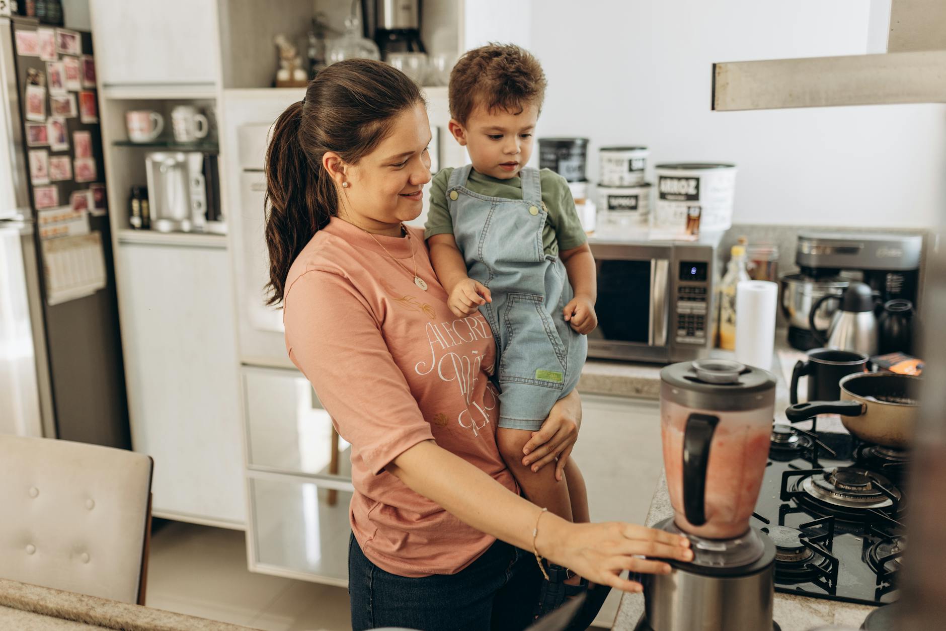 son and smiling mother in kitchen