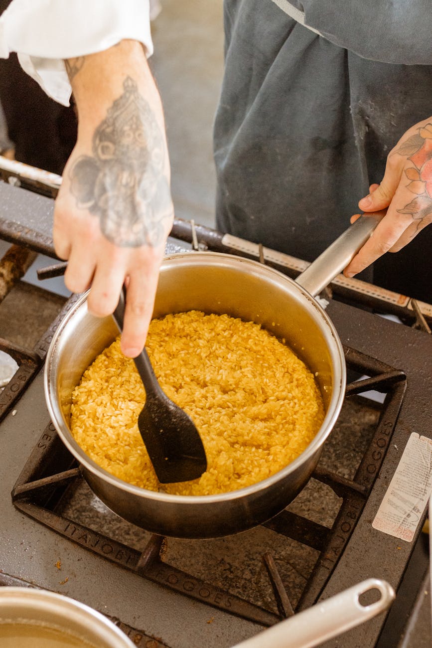 chef stirring risotto on kitchen stove