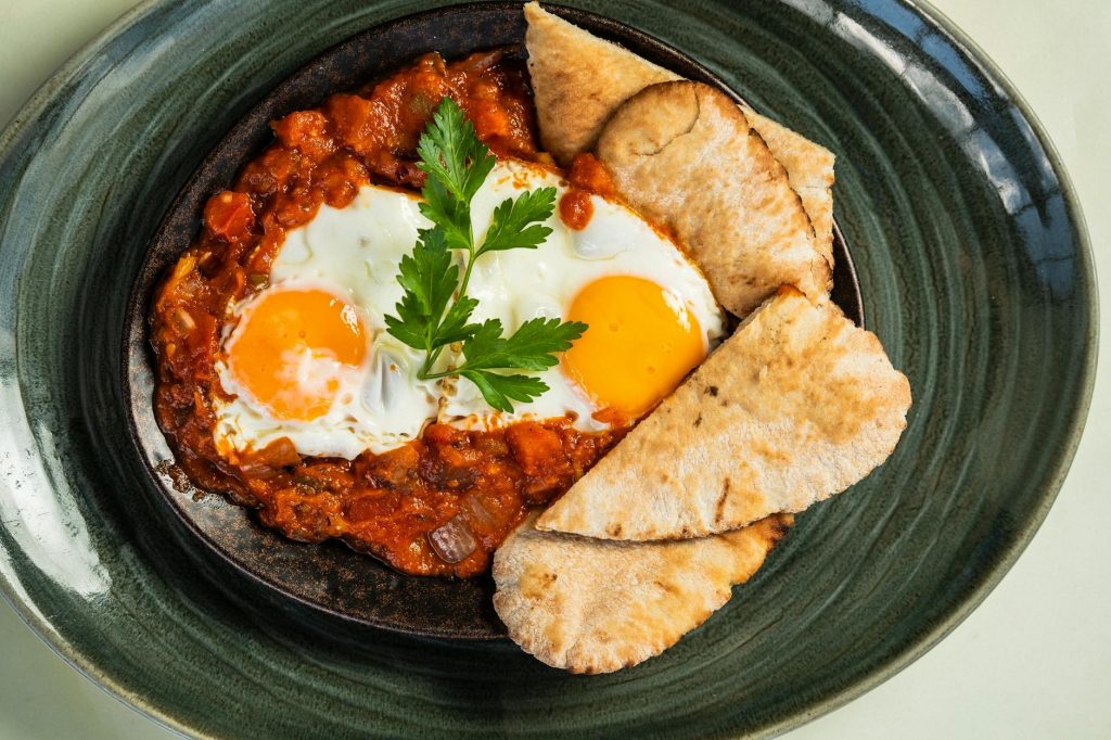 delicious shakshouka with eggs and pita bread