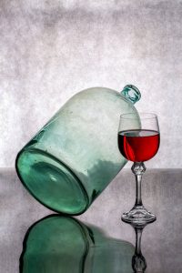 elegant wine glass with green bottle reflection