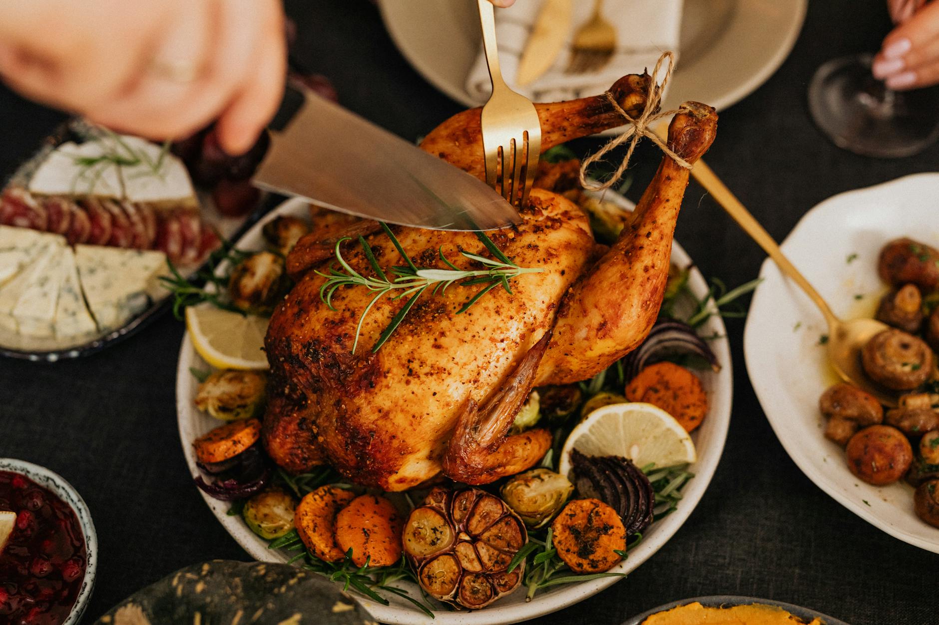 person cutting roasted chicken