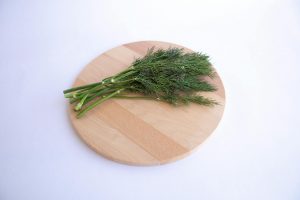 green vegetable on brown wooden round chopping board