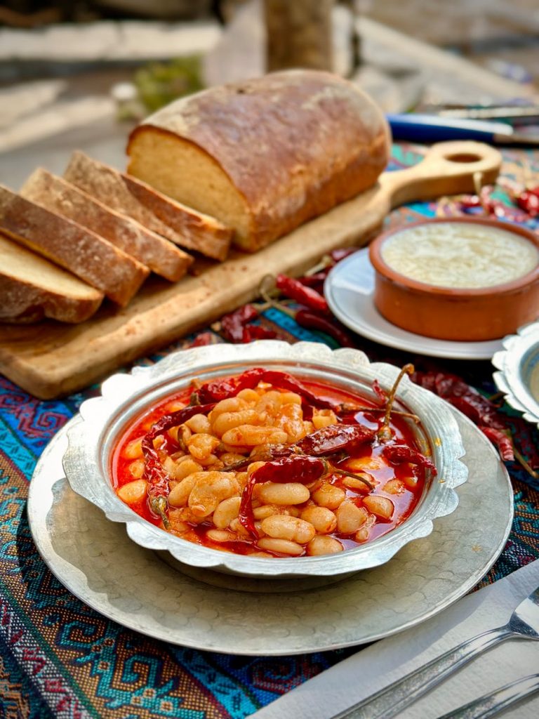 a table with bread beans and a bowl of soup