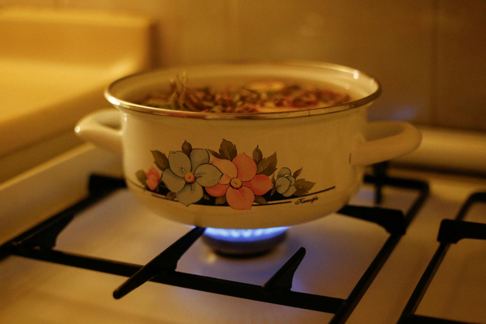 enamel pot on gas stove with steaming soup