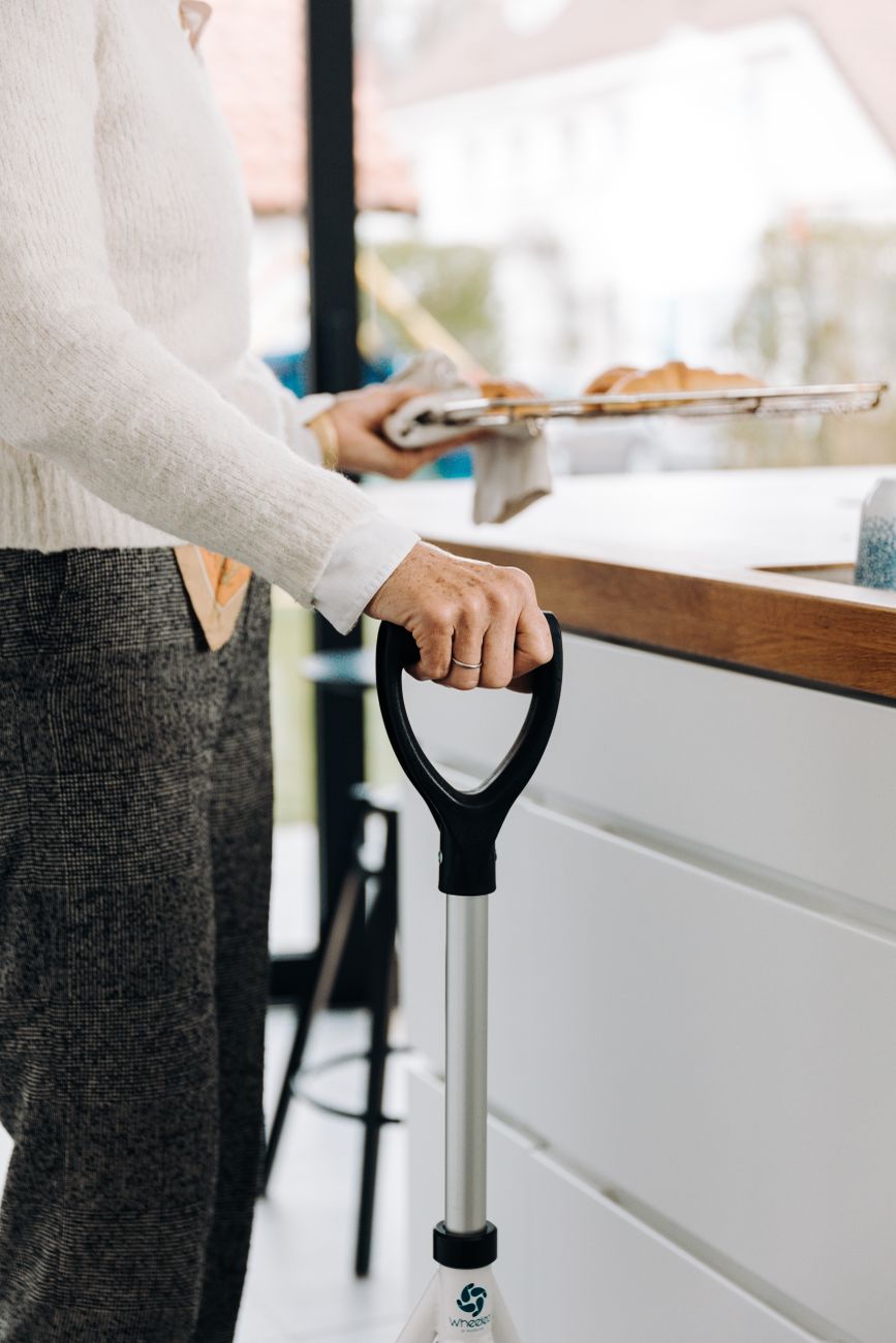senior adult using mobility aid in modern kitchen
