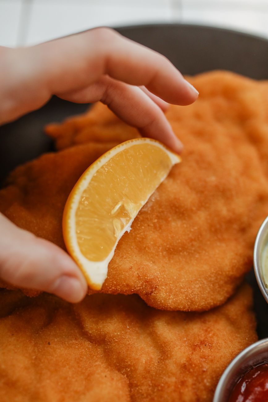a lemon cut over a battered fried dish