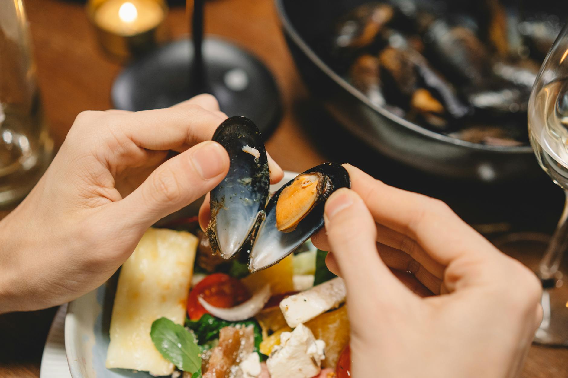 a person opening a mussel