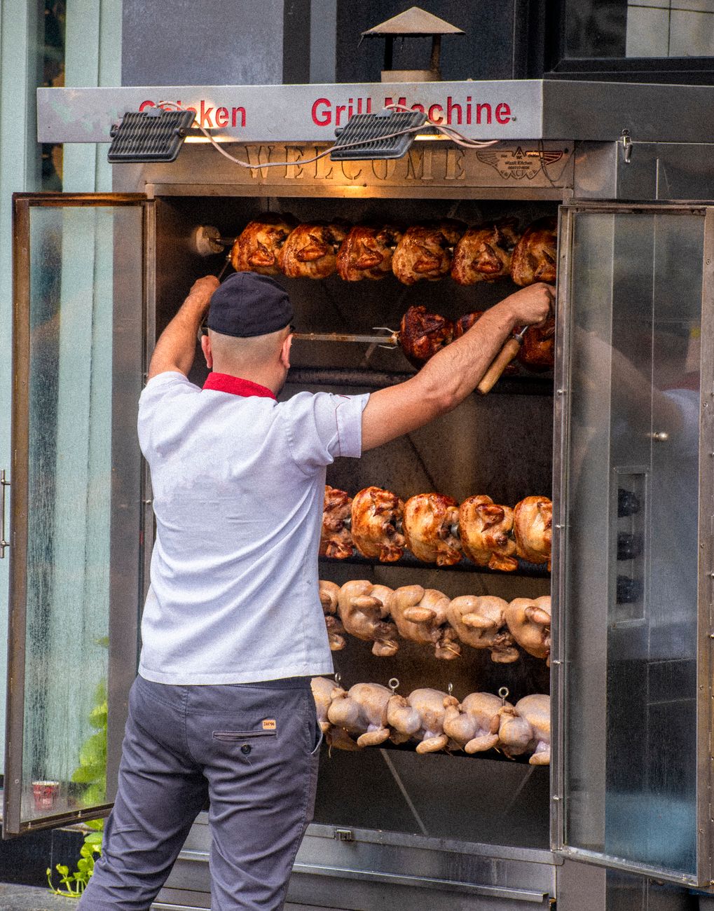 man stands by grill machine