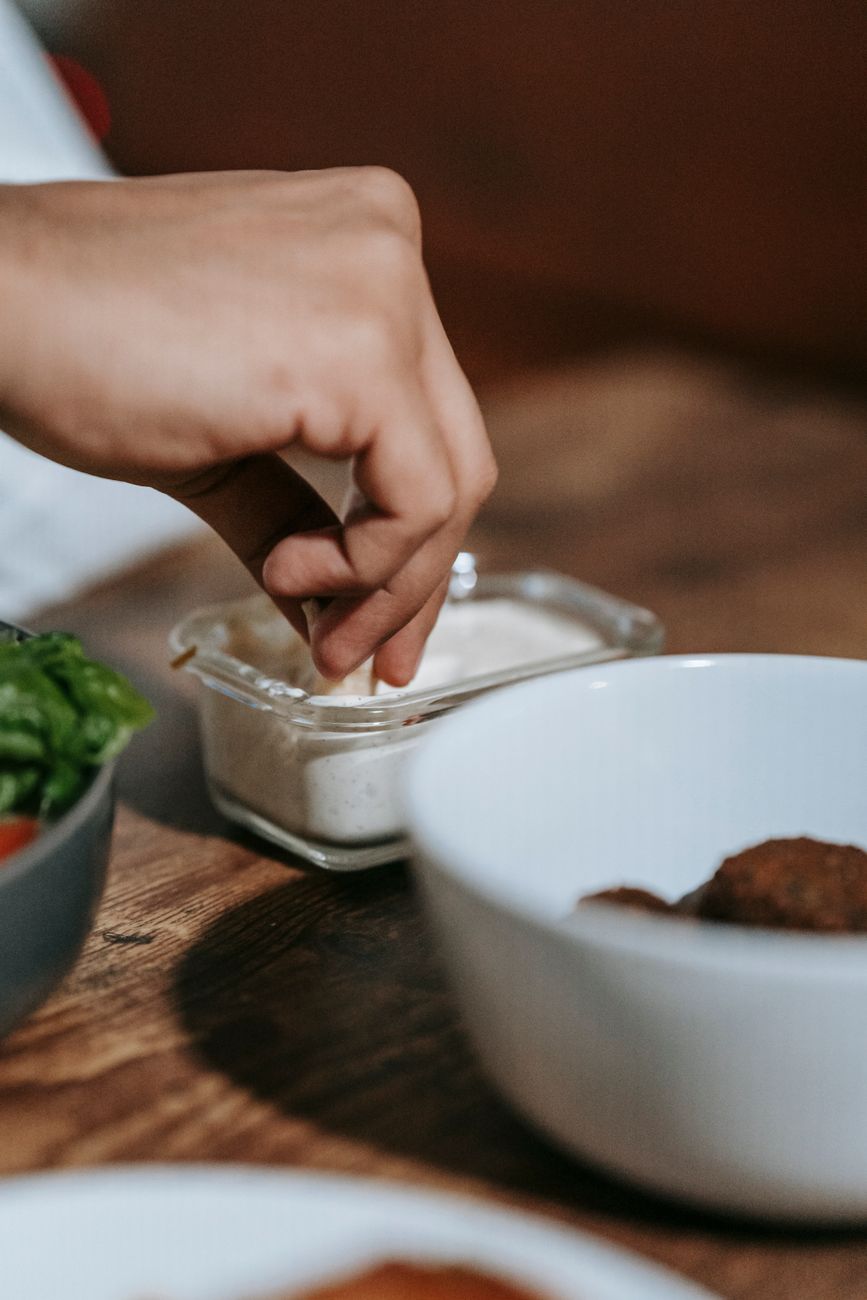 person dipping on white sauce