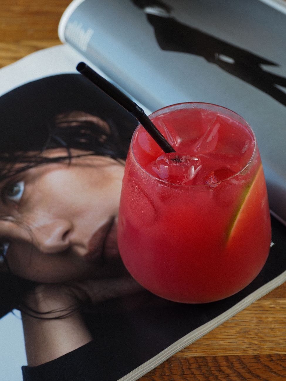 glass of a red drink on a magazine