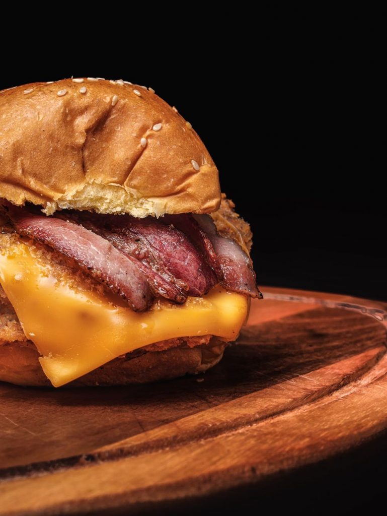 delicious cheeseburger on wooden plate