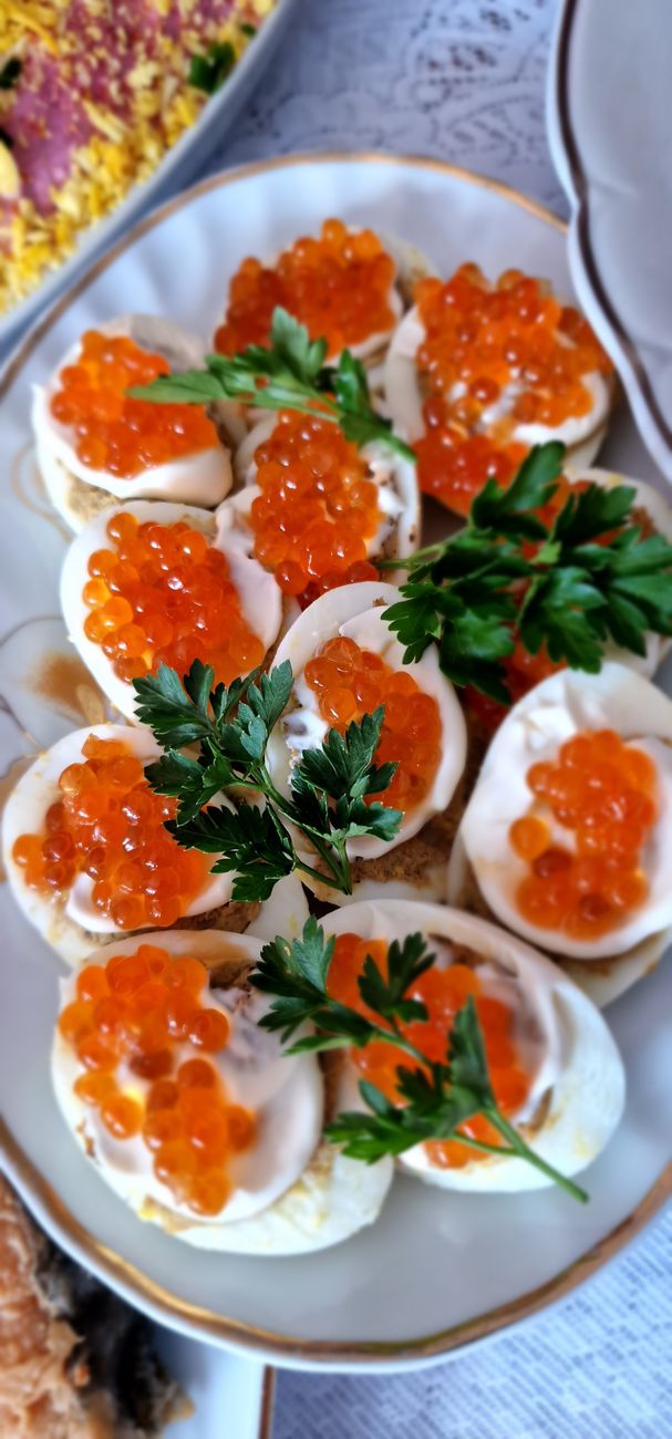 gourmet deviled eggs with red caviar and parsley