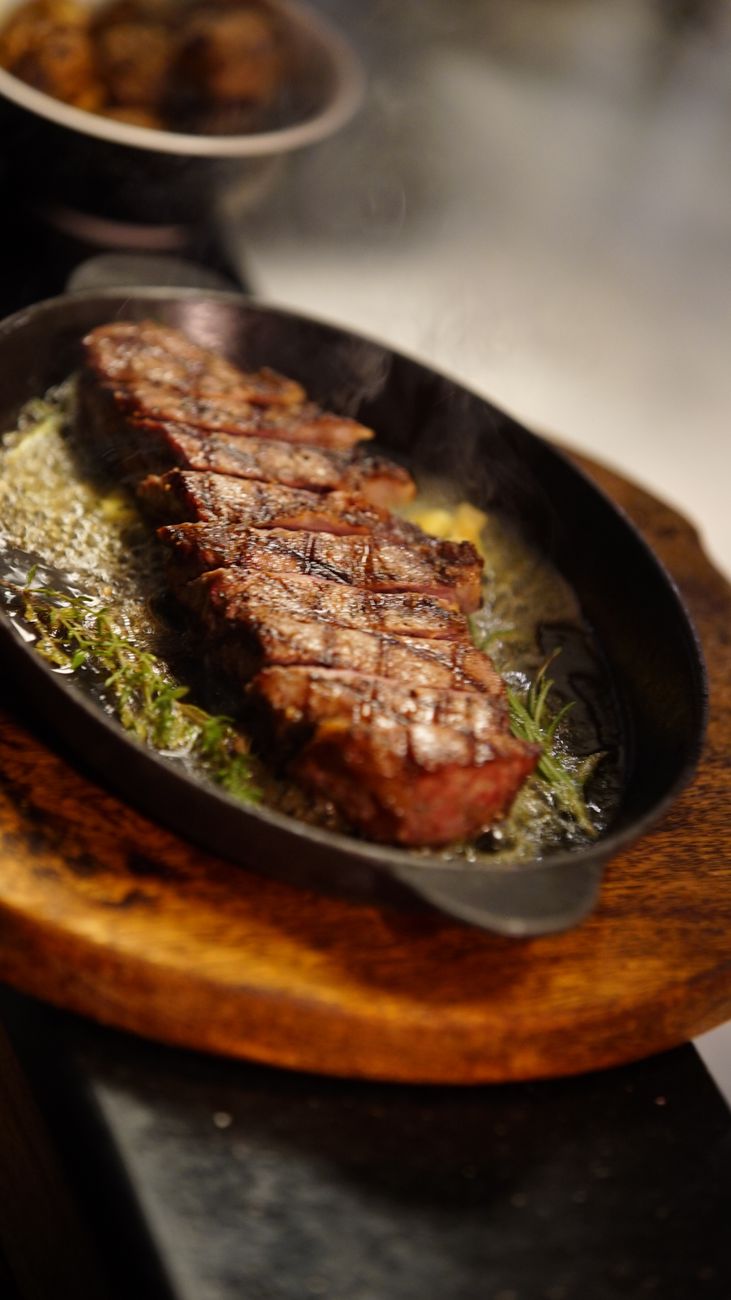 sizzling grilled steak on hot skillet
