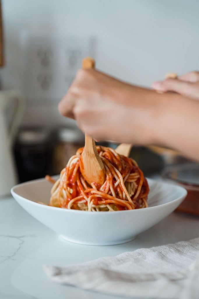 close up shot of a person mixing a delicious spaghetti