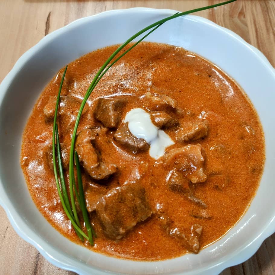 Kalbsrahmgulasch angerichtet in einer Porzellanschüssel