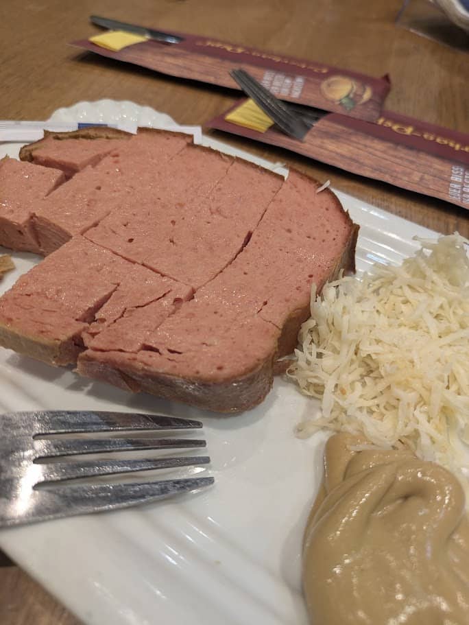 Geschnittener Leberkäse mit Senf und Kren